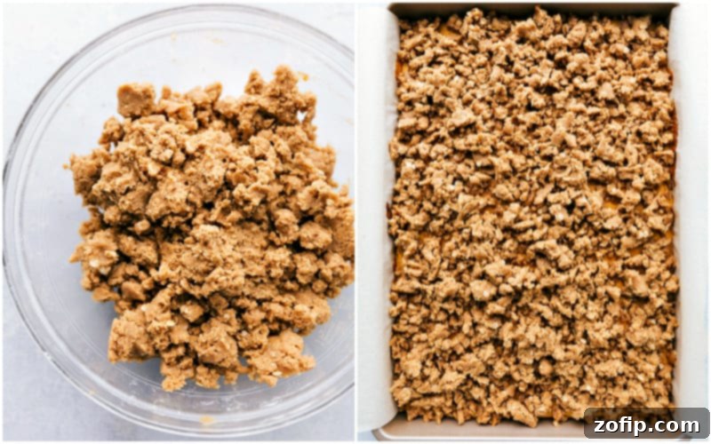 A close-up of a perfectly cut pumpkin cheesecake bar, showing the layers of crust, plain cheesecake, pumpkin cheesecake, and streusel topping, with a drizzle of caramel.