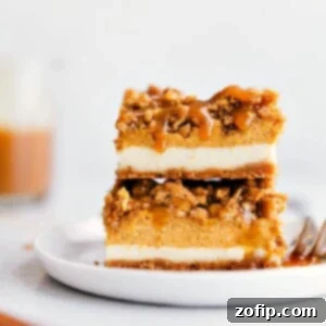 A beautifully sliced pumpkin caramel cheesecake bar with streusel topping and a rich caramel drizzle, showcasing its tempting layers.