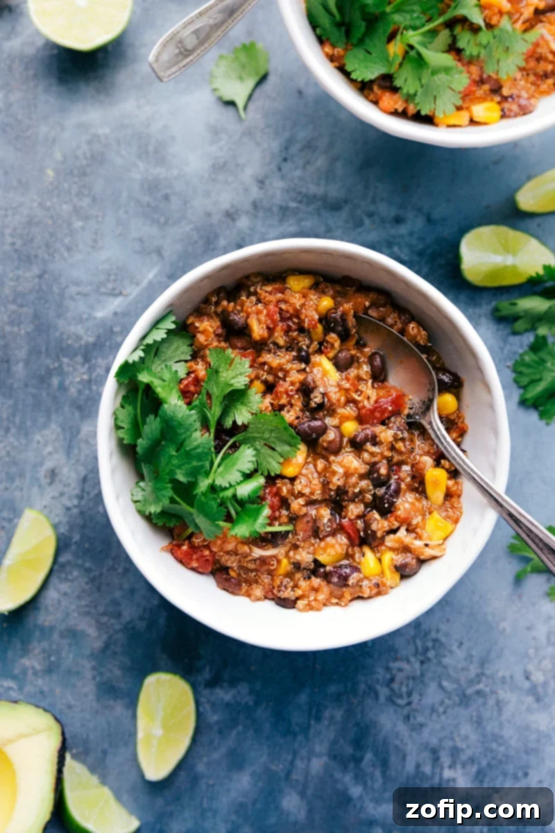 A steaming bowl of Crockpot Quinoa Chili, generously topped with vibrant fresh cilantro, signifying a delicious and ready-to-eat meal.