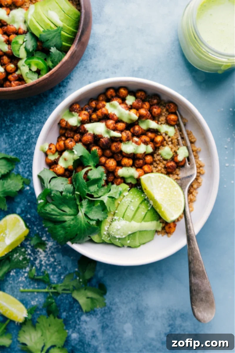 A vibrant bowl of perfectly spiced Mexican Chickpeas, roasted and topped with creamy cilantro-lime sauce, fresh avocado, and a sprinkle of cilantro. Ideal for a healthy, quick, and easy plant-based dinner.