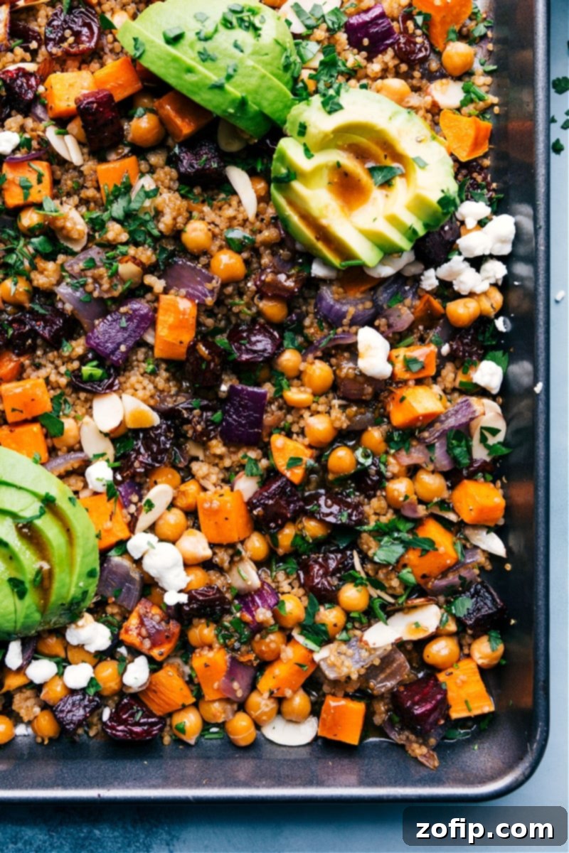 Overhead view of the colorful Sheet Pan Quinoa Pilaf served directly on a sheet pan, showcasing roasted vegetables, quinoa, and fresh toppings.