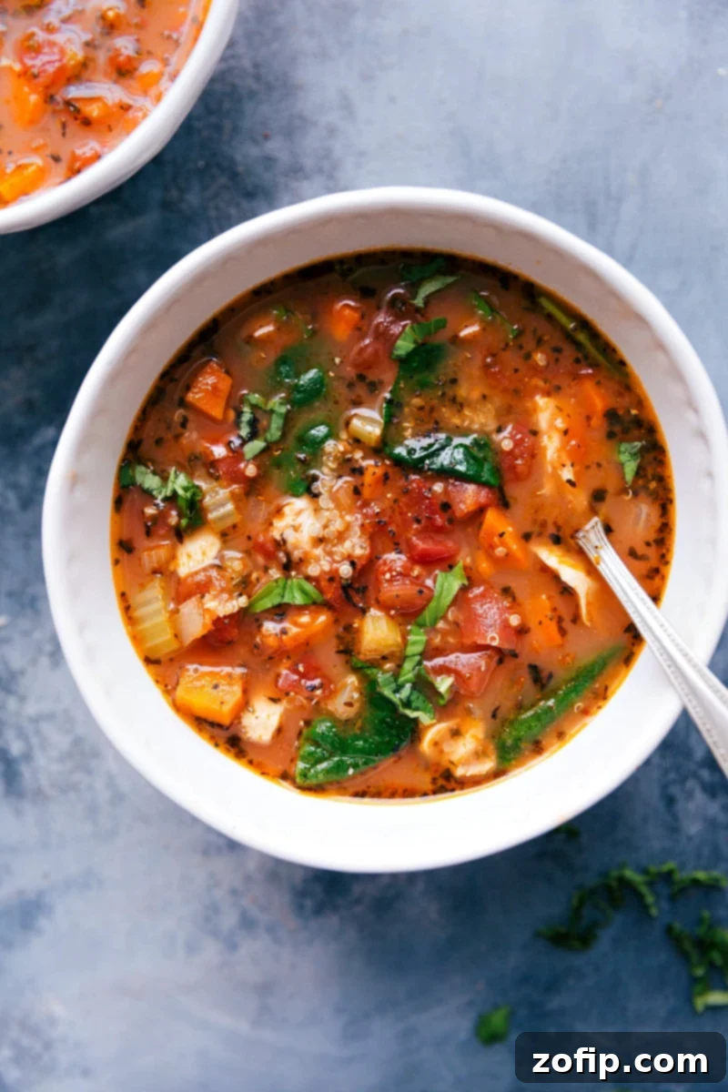 A beautifully presented bowl of hearty crockpot chicken quinoa soup, featuring tender chicken, fluffy quinoa, colorful vegetables, and a sprinkle of fresh herbs.