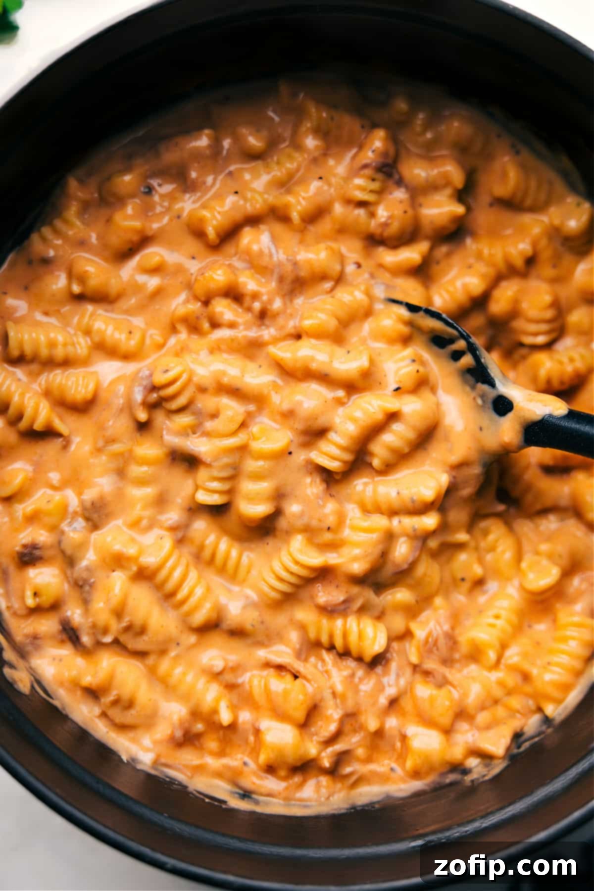 Hot and ready BBQ Mac and Cheese in a large pot, with a serving spoon, inviting you to dig in!
