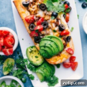 Close-up of a delicious French Bread Taco Pizza, with vibrant toppings, melted cheese, and seasoned beef.