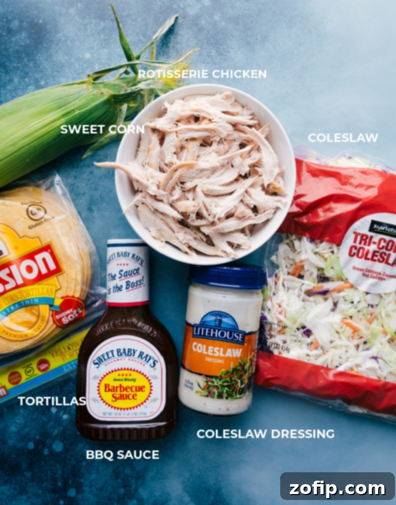 A flat lay photograph showcasing all the fresh and simple ingredients required for making BBQ Chicken Tacos with Coleslaw, including chicken, corn, coleslaw mix, dressing, and tortillas.