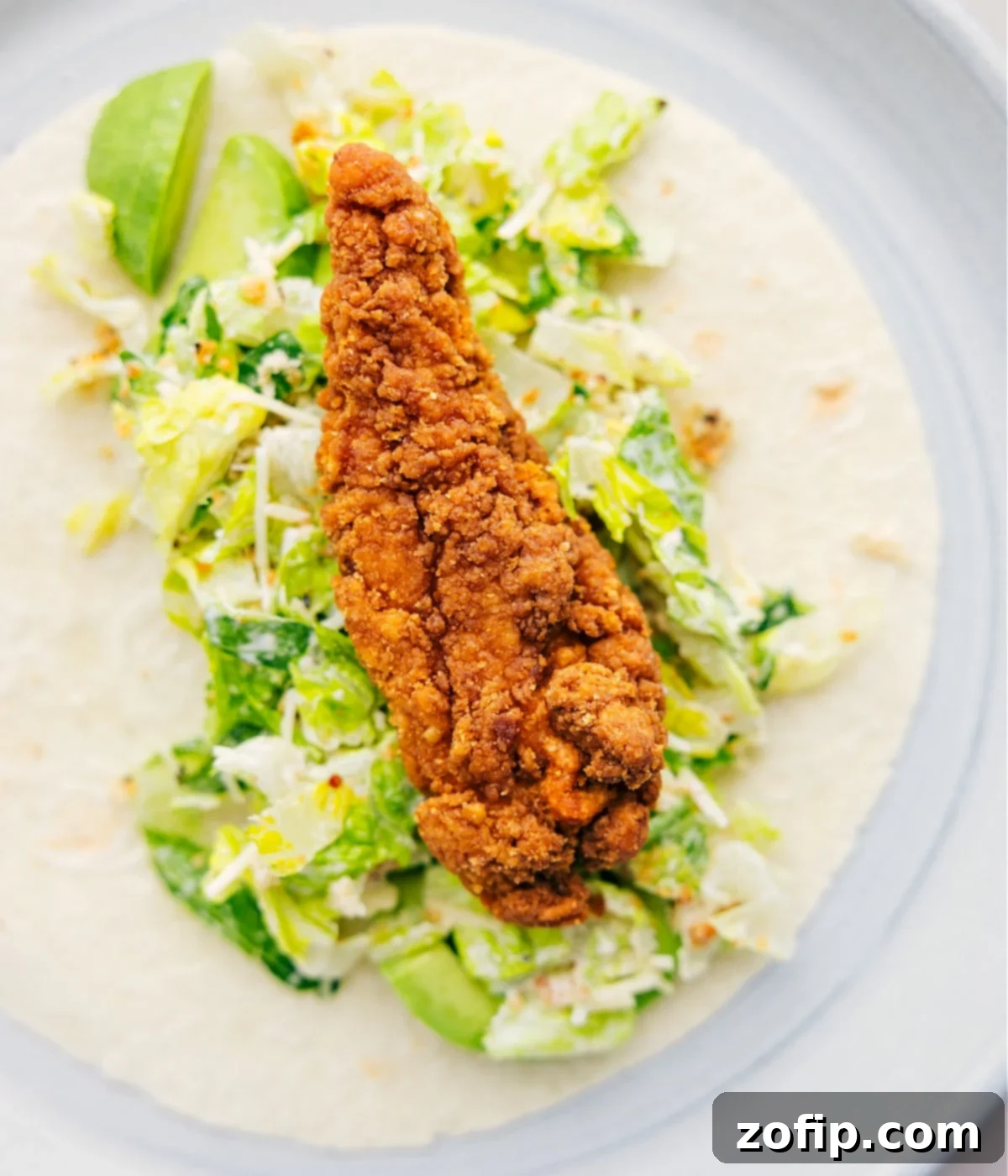 Assembling the Perfect Chicken Caesar Wrap for Lunch Piling in all the components of the Chicken Caesar Wrap inside a tortilla.