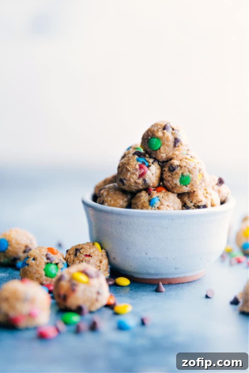 Monster Energy Balls: A nutritious and delicious no-bake snack, loaded with peanut butter, oats, chocolate chips, and M&M's. Perfect for a quick energy boost! A bowl overflowing with delicious Monster Energy Bites, featuring oats, peanut butter, and colorful M&M's.