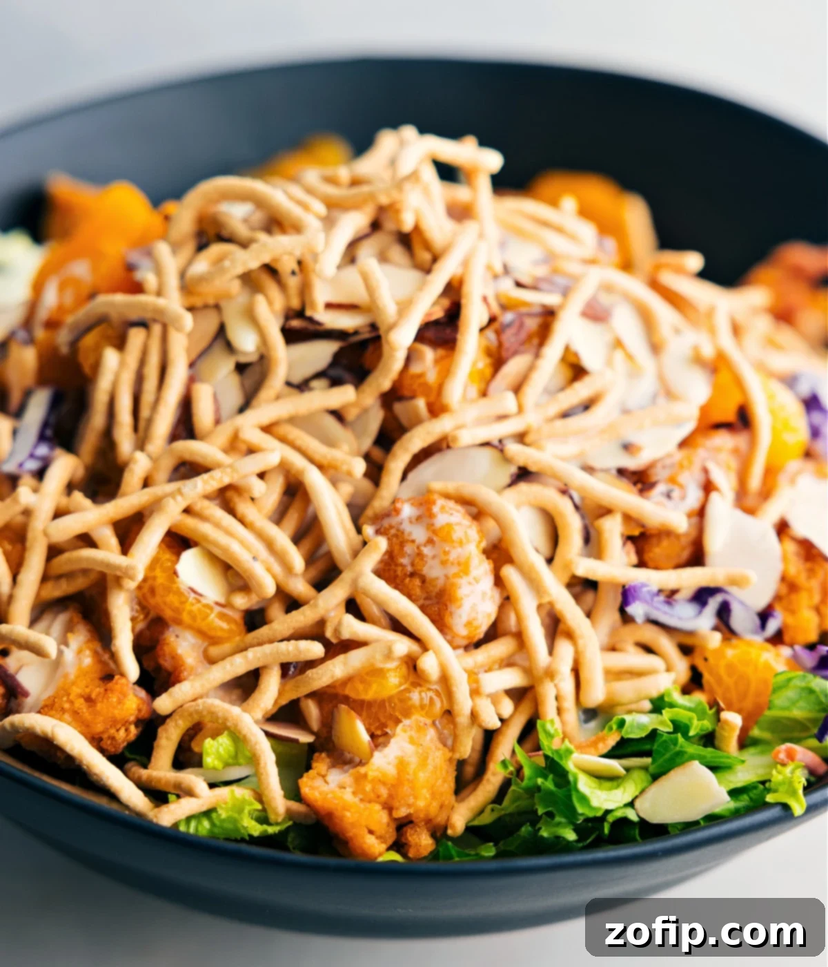 The dish tossed together in a bowl showing the crispy chow mein noodles.