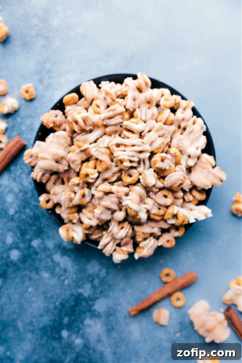 Churro Cheerios: A delightful and easy-to-make after-school snack, perfect for any sweet craving. Find the recipe at ChelseasMessyApron.com #snack #afterschool #cheerios #cereal #churros #whitechocolate #easyrecipe #dessert Overhead image of the Churro Cheerios arranged on a serving platter, highlighting their caramelized, white chocolate-drizzled, and cinnamon-sugar coated appearance.