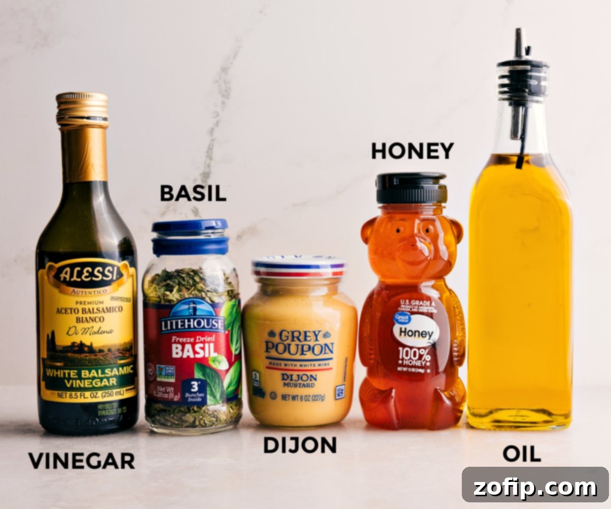 All the dressing ingredients including honey, olive oil, Dijon mustard, dried basil, and white balsamic vinegar, ready to be mixed for the Summer Couscous Salad.