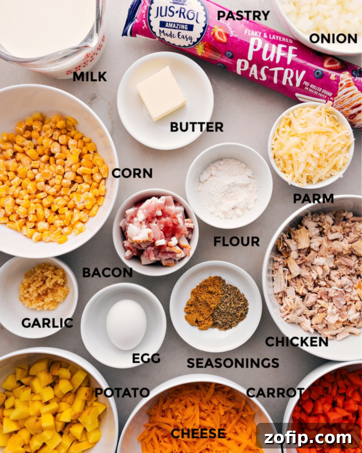 All the fresh and prepared ingredients for the Corn Chowder Pot Pie are neatly arranged, showcasing vibrant vegetables, cooked chicken, and dairy, ready for assembly.