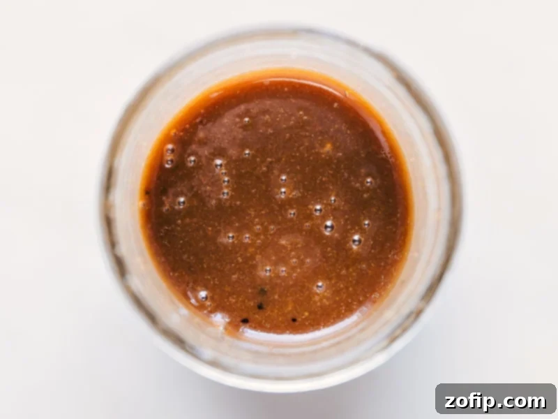 A clear glass jar filled with perfectly mixed homemade Balsamic Vinaigrette, showcasing its creamy, emulsified texture, ready for use.