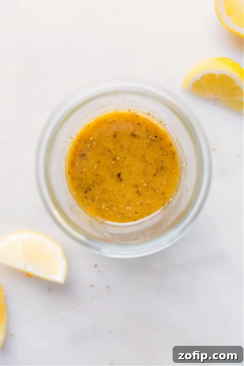 A close-up shot of a bowl of fresh Greek Salad Dressing, highlighting its vibrant color and fresh ingredients.