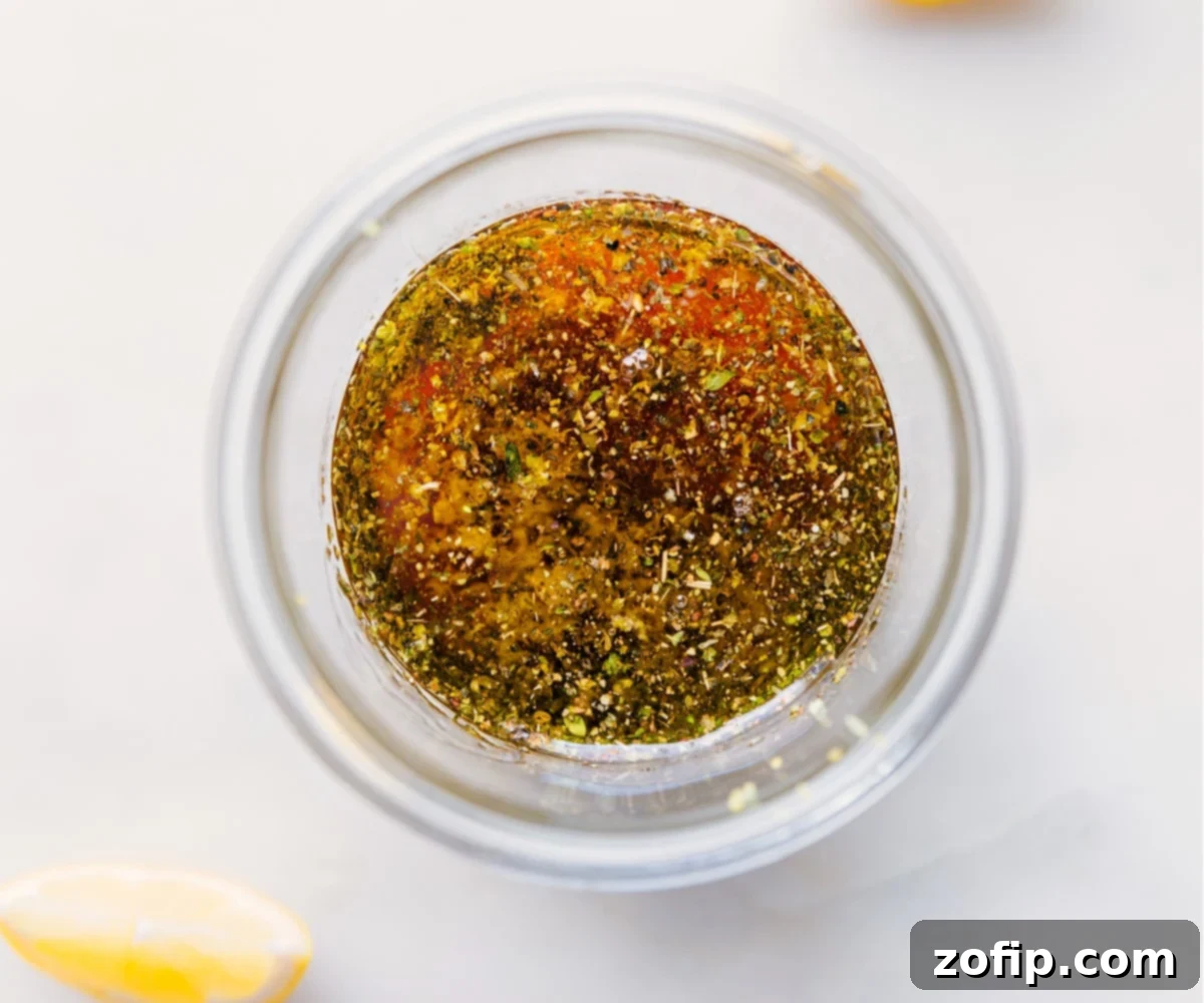 All ingredients for Lemon Vinaigrette being added into a mason jar before shaking.
