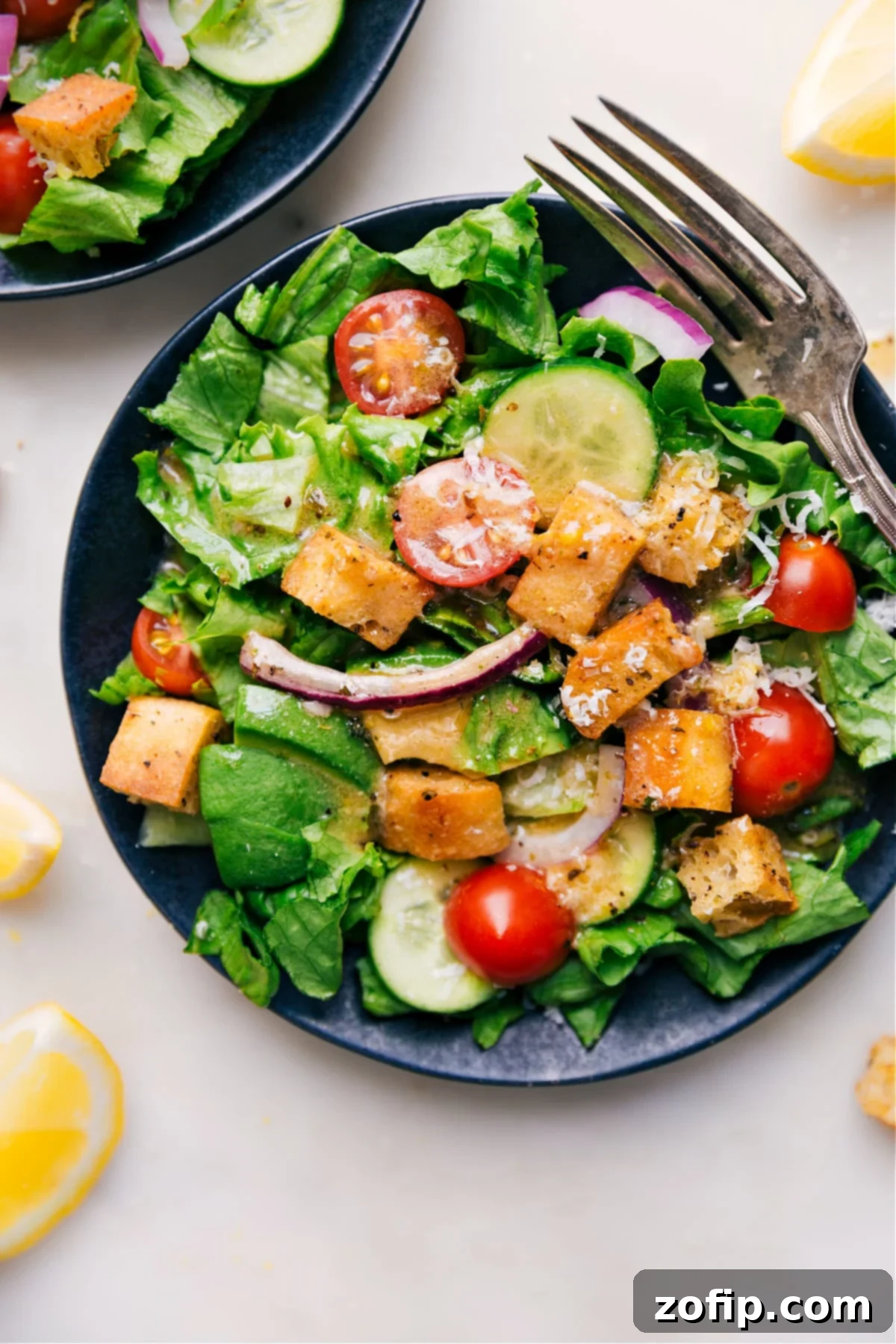 Lemon Vinaigrette being poured generously over a fresh green salad for a zesty meal.