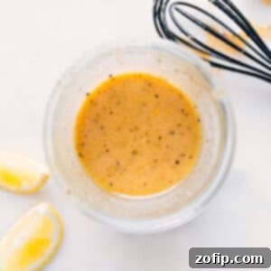 Homemade Lemon Vinaigrette in a glass jar with fresh lemons.