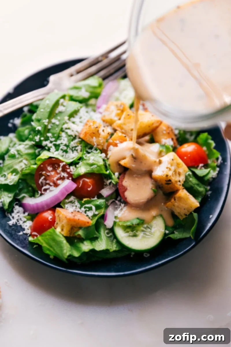 Image of the vibrant Italian Dressing being generously poured over a fresh, colorful salad, showcasing its perfect consistency.