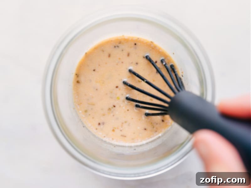 Overhead image capturing the process of whisking homemade Italian Dressing, highlighting its smooth and well-emulsified texture.