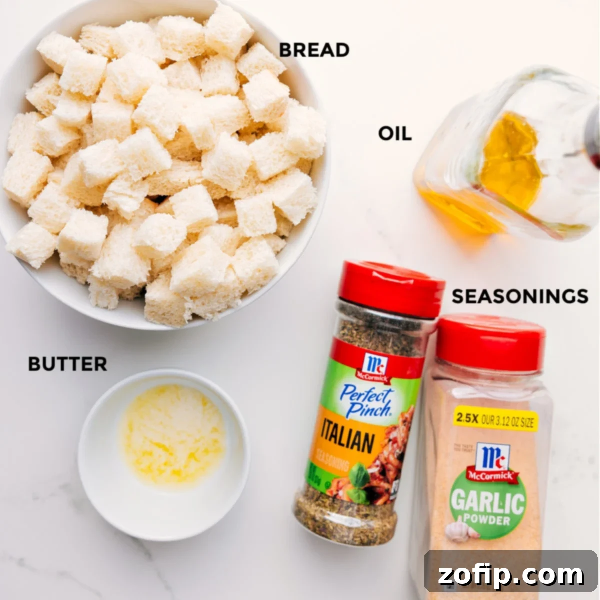 Ingredients In Homemade Croutons All ingredients prepped for easy assembly of homemade croutons, including cubed bread, olive oil, melted butter, Italian seasoning, garlic powder, salt, and pepper.