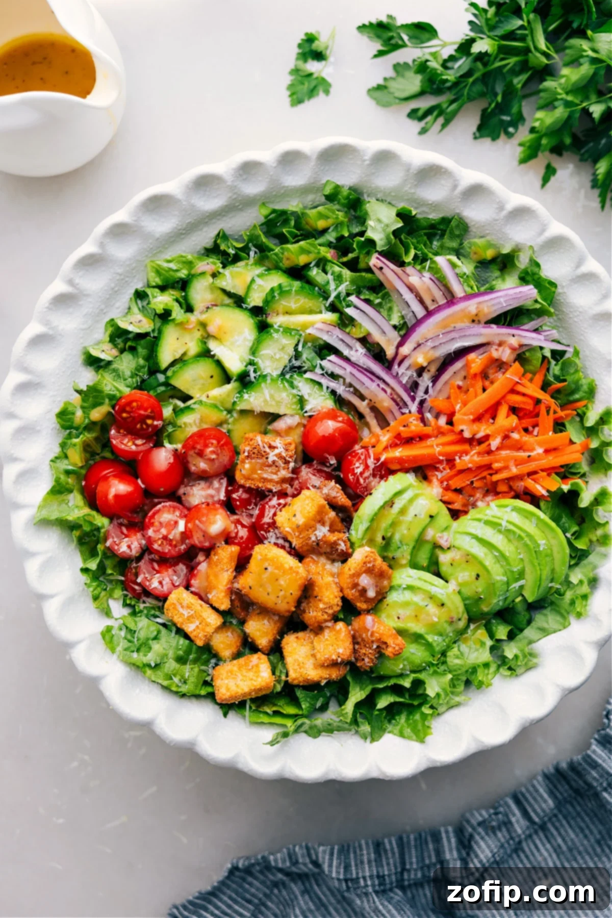 Freshly prepared garden salad in a large wooden bowl, showcasing crisp lettuce, vibrant tomatoes, and refreshing cucumbers.