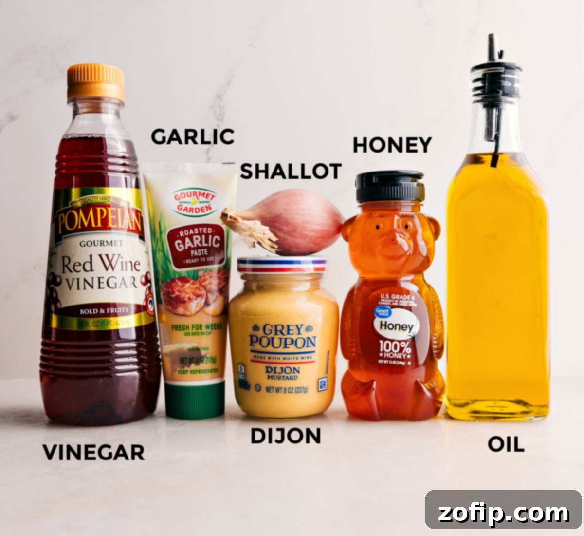 Ingredients for a quick and simple garden salad dressing: honey, olive oil, shallot, Dijon mustard, garlic, and red wine vinegar.