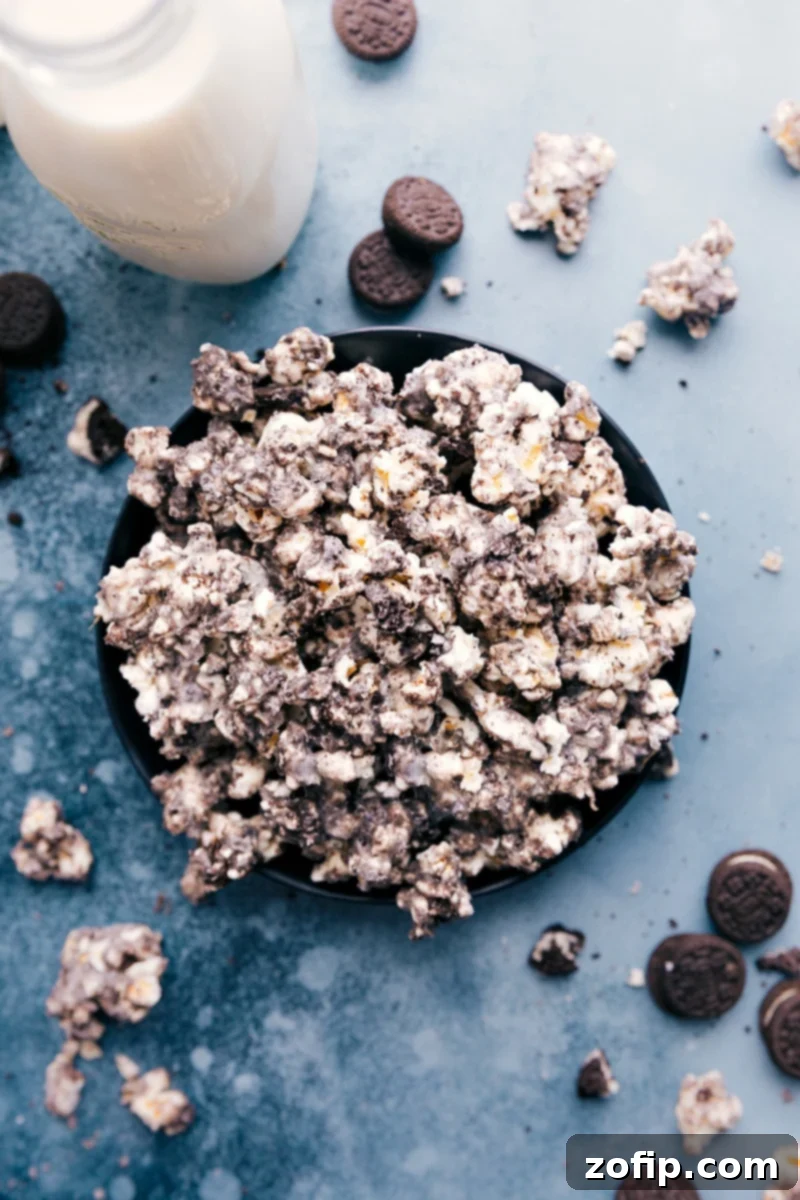 A close-up image of finished Oreo Popcorn in a serving bowl, showcasing the white chocolate and crushed cookie pieces