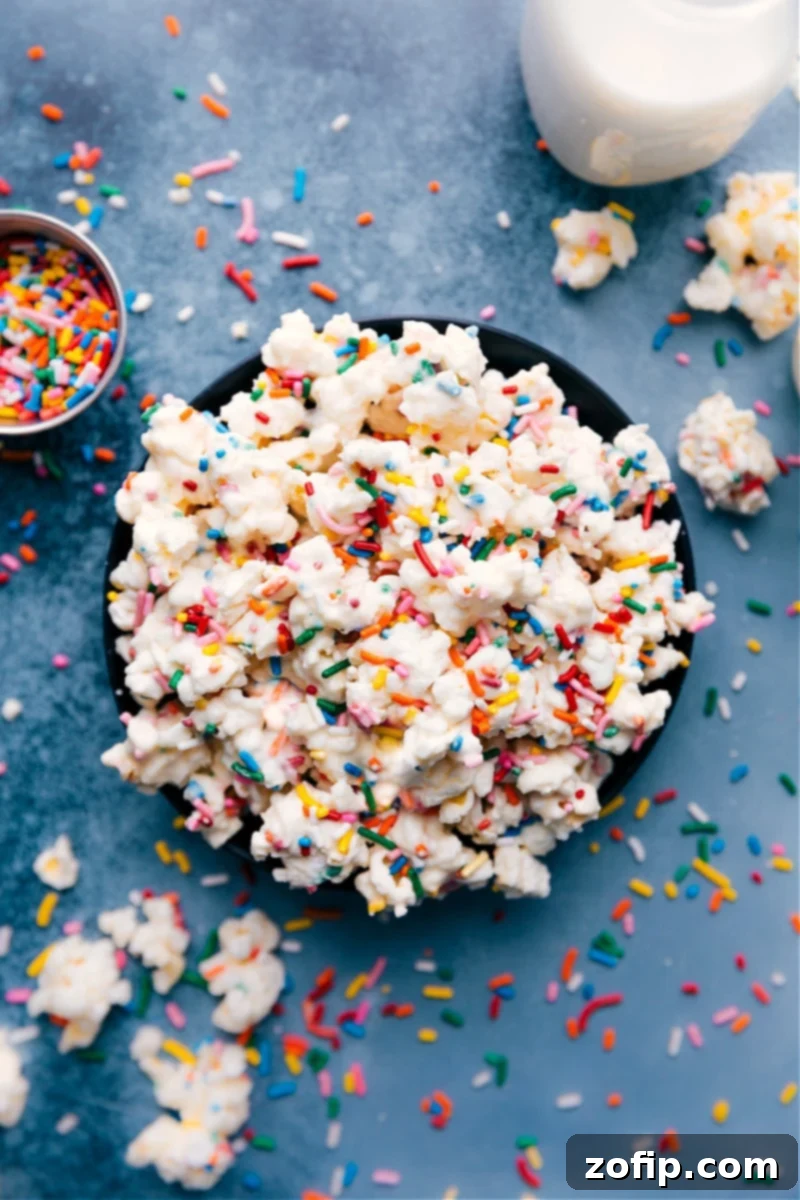 Sweet, crunchy Cake Batter Popcorn loaded with sprinkles – a perfect homemade treat! Cake Batter Popcorn generously coated in white chocolate and colorful sprinkles, ready to be enjoyed.