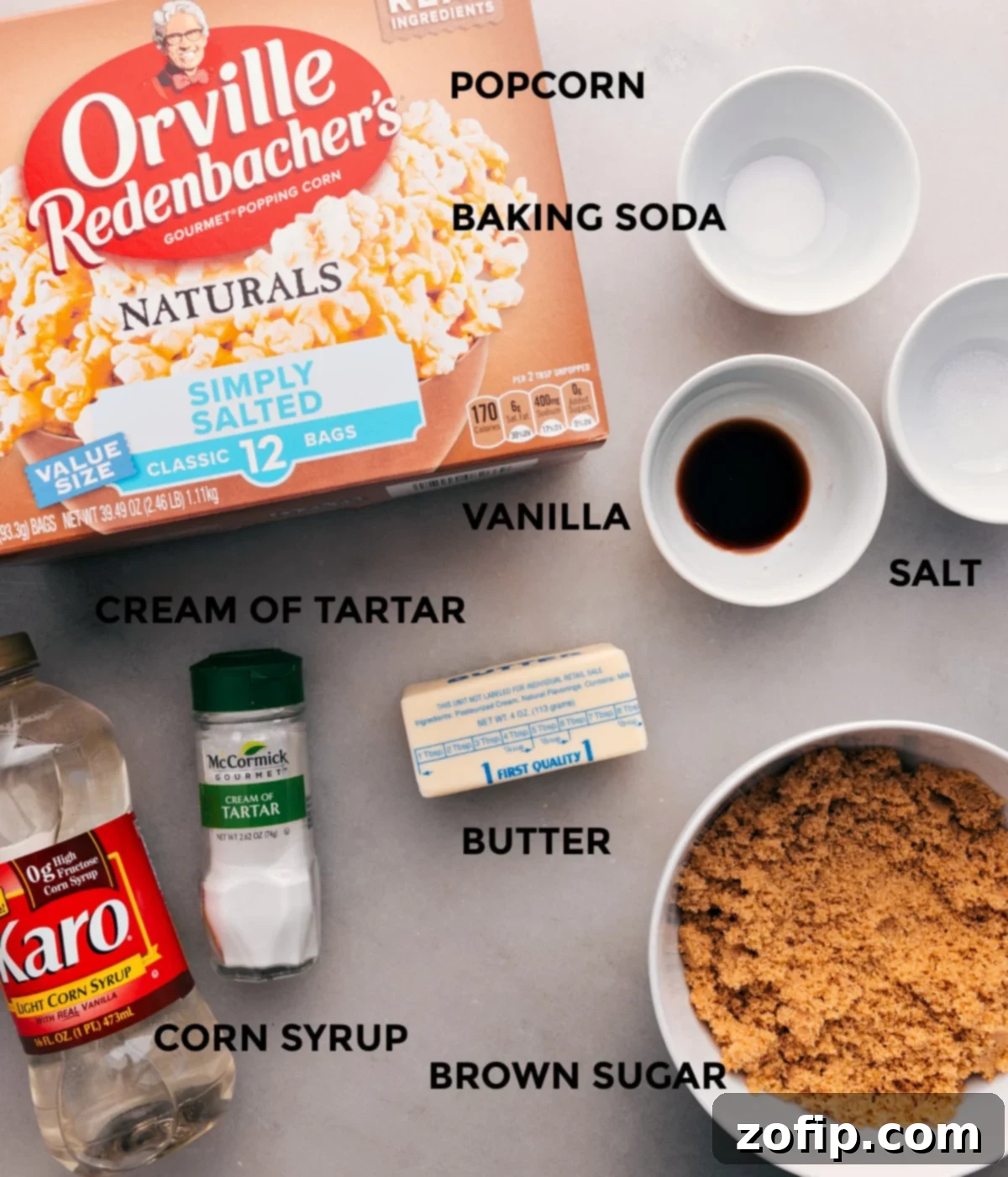All the ingredients for this recipe are prepped for easy assembly: baking soda, salt, vanilla, butter, sugar, corn syrup, cream of tartar, and popcorn.