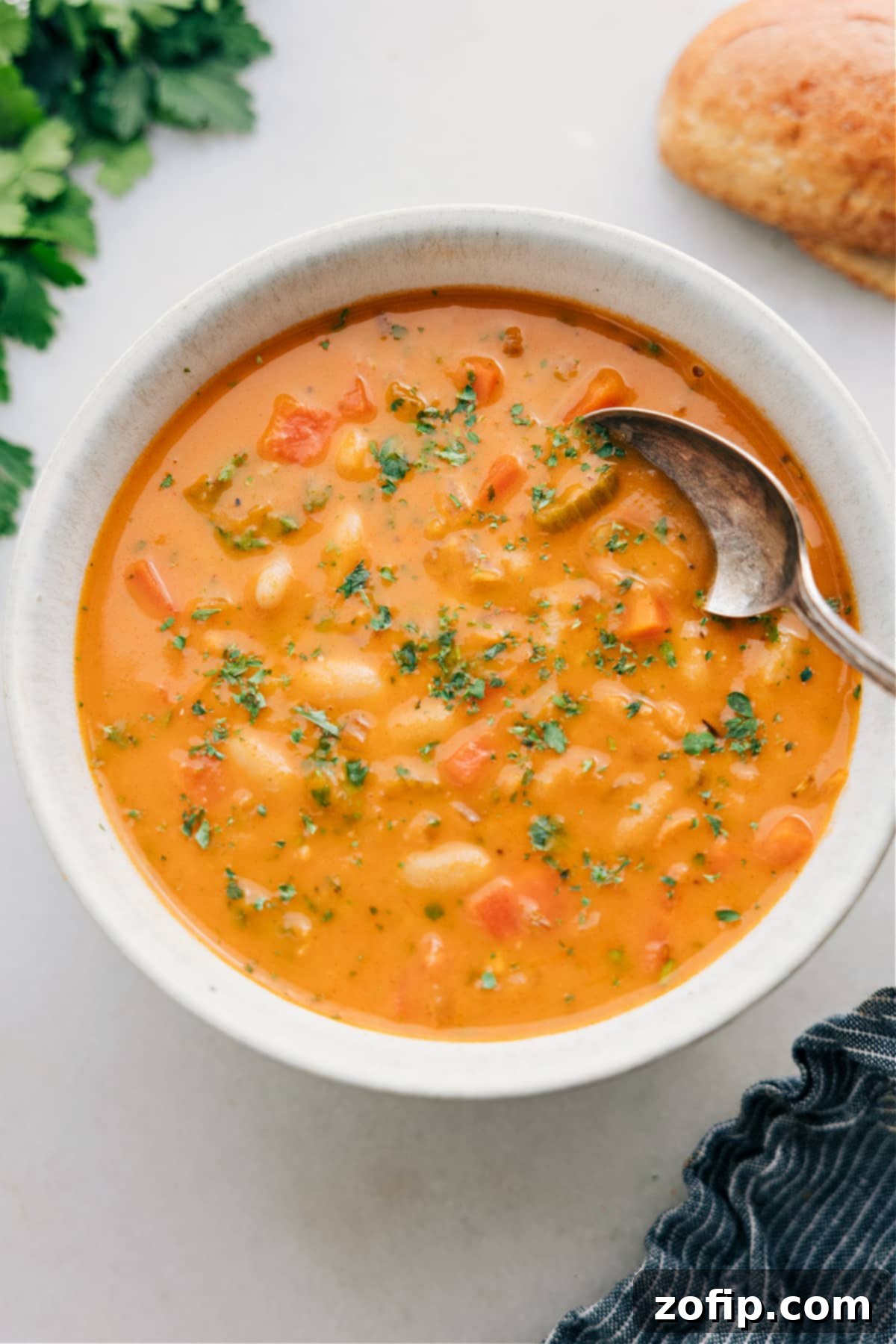 A warm, inviting bowl of White Bean Soup, garnished with fresh herbs and a drizzle of pesto, ready to be enjoyed as a comforting meal.