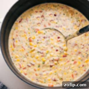 Creamy Corn Chowder 2 A bowl of creamy corn chowder garnished with bacon and herbs.