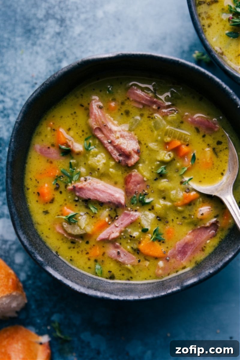 Overhead image of a beautifully presented bowl of Split Pea Soup, garnished with fresh herbs, ready to be served.