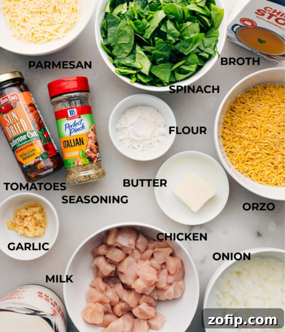 All the ingredients in this recipe are prepped for easy assembly, including spinach, broth, veggies, pasta, meat, seasonings, cheese, and milk.