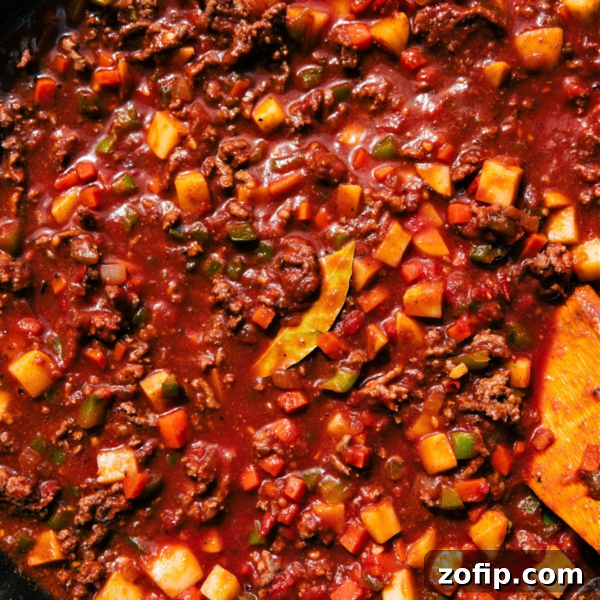 Delicious Mexican Picadillo Simmering in a Skillet Mexican Picadillo simmering gently in a large skillet, rich with ground beef, tender potatoes, and a savory tomato sauce. The vibrant colors of the ingredients are visible through the bubbling sauce, indicating a delicious meal in progress. Steam rises invitingly from the pan, highlighting the warmth and comfort of the dish.