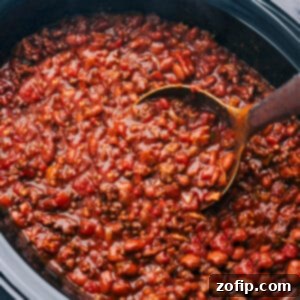 A steaming bowl of delicious slow cooker chili with toppings.
