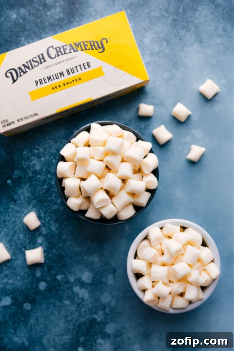 Two bowls of pastel-colored homemade Butter Mints, with a stick of butter nearby, showcasing their inviting appearance.