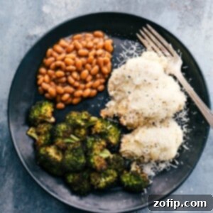 Baked alfredo chicken served on a plate with beans and baked broccoli.