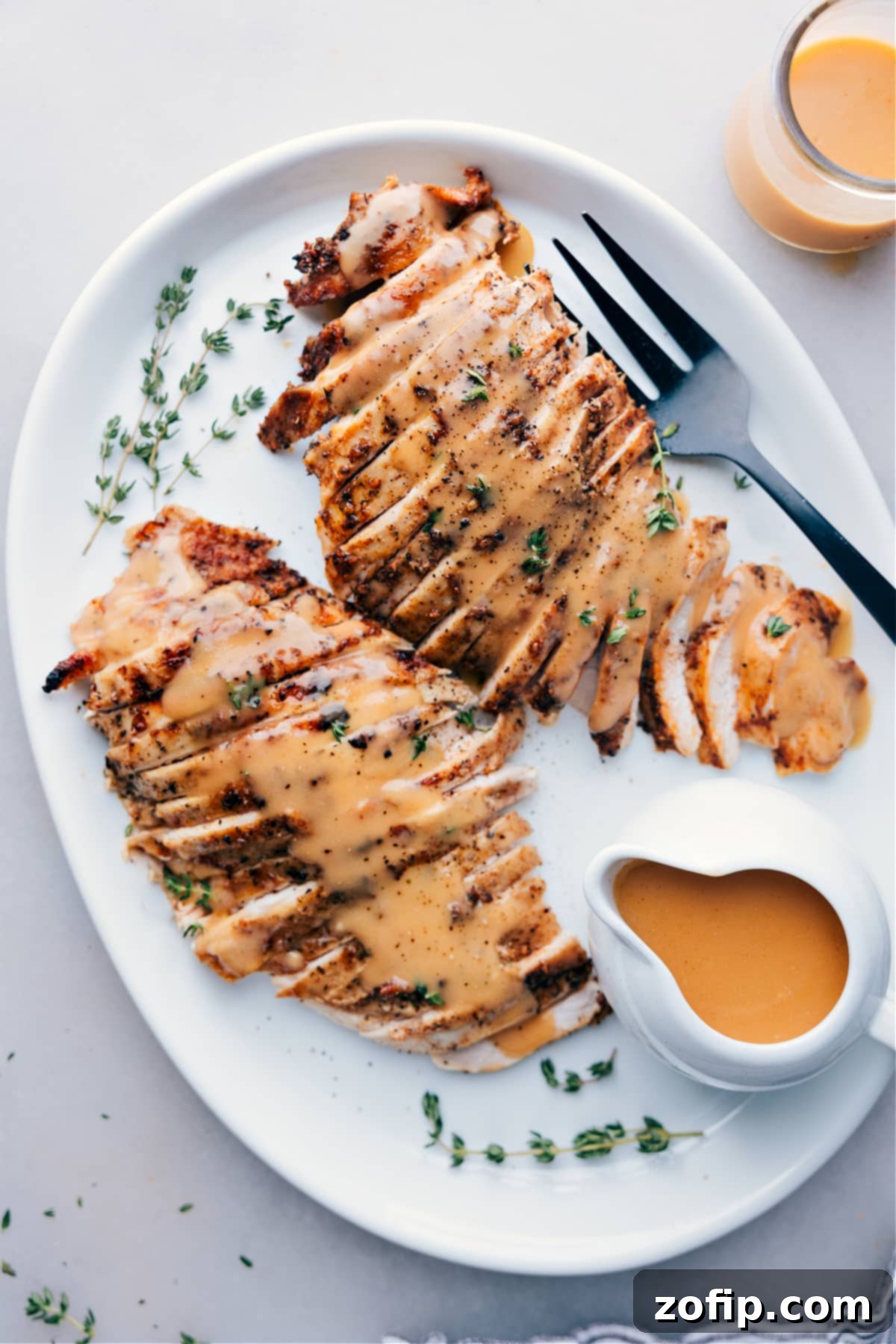 Succulent slices of slow-cooked turkey breast, draped with rich gravy and adorned with fresh herbs, ready to be served.