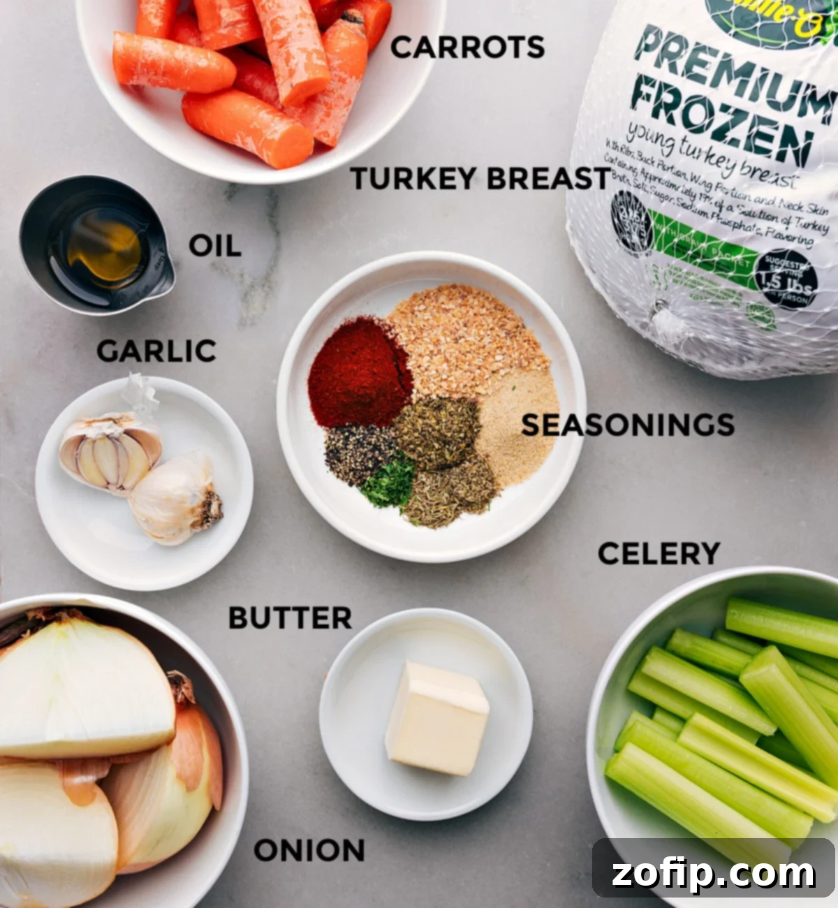 A vibrant selection of fresh ingredients including butter, yellow onions, crisp carrots, and various aromatic seasonings, laid out for a flavorful turkey recipe.