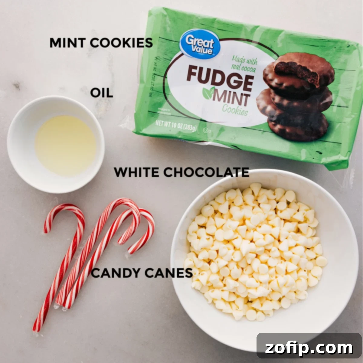 The four essential ingredients for making these Peppermint Cookies: fudge mint cookies, white chocolate melting wafers, coconut oil, and candy canes.