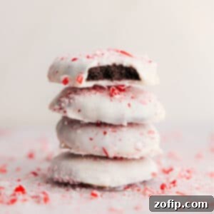 Close-up of a stack of Peppermint Cookies, showing the white chocolate coating and crushed candy canes.
