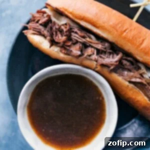 The finished French Dip Sandwich with tender beef, melted cheese, and a side of au jus for dipping.