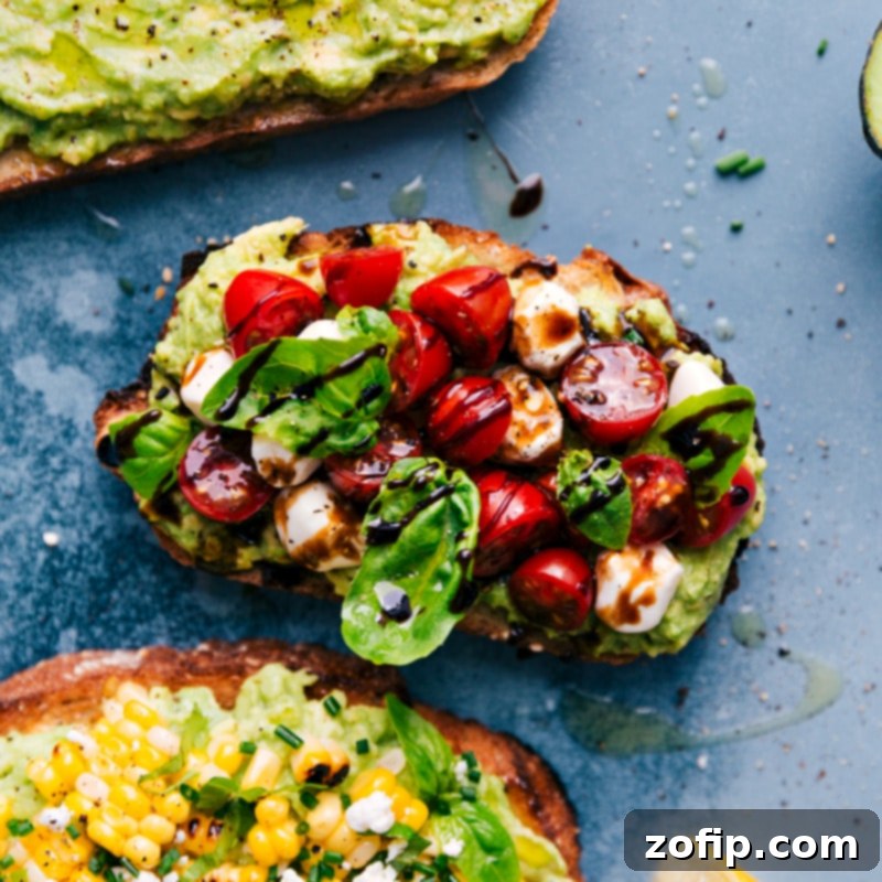 An overhead image of the Caprese version of Avocado Toast, adorned with cherry tomatoes, mozzarella pearls, basil, and a drizzle of balsamic glaze.