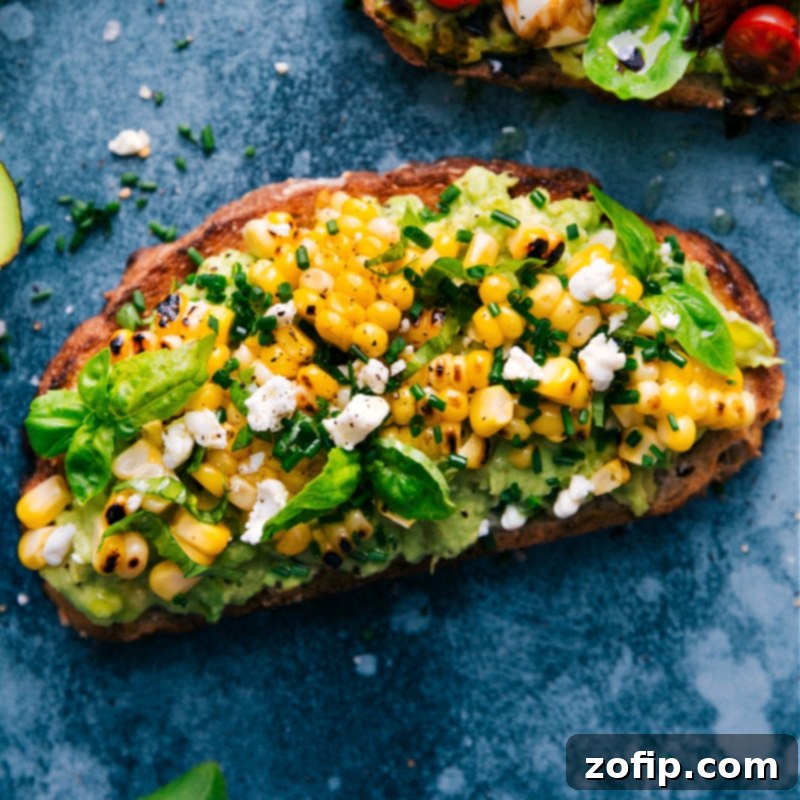An overhead image of the Sweet Corn and Herb Avocado Toast, garnished with fresh herbs and corn kernels.
