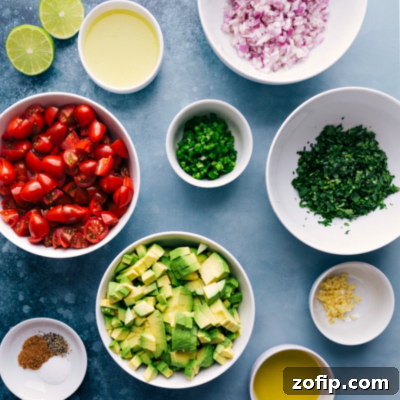 Ingredient shot - all fresh ingredients for avocado salsa laid out on a kitchen counter