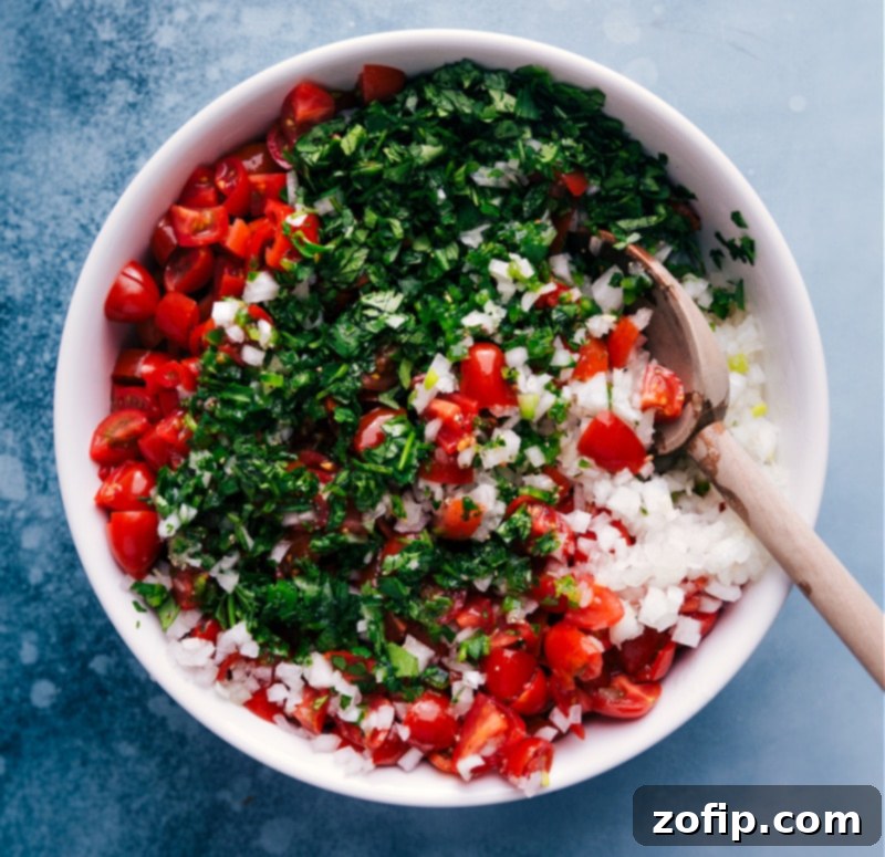 Overhead image of Pico de Gallo being gently tossed together in a bowl