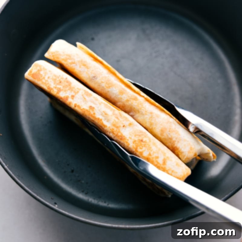 Zesty BBQ Chicken Roll-ups 8 Freshly crisped BBQ Chicken Wraps being removed from the skillet, showcasing their golden-brown and crunchy texture.
