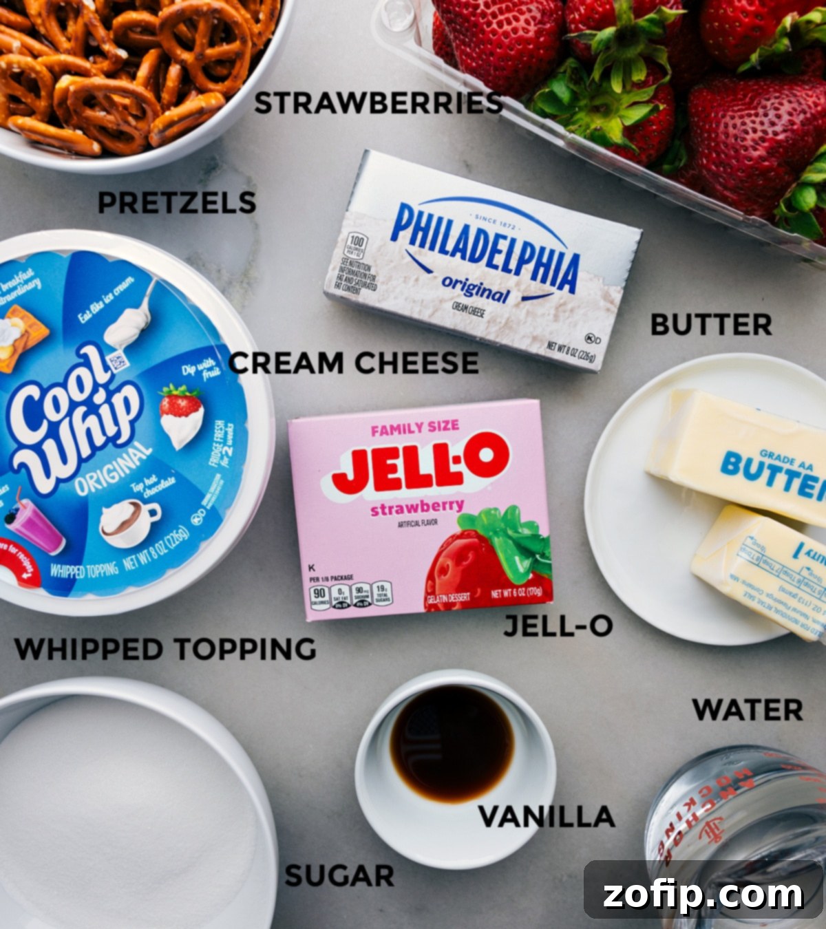 Ingredients For Strawberry Pretzel Salad Assortment of fresh ingredients laid out for making Strawberry Pretzel Salad, including pretzels, cream cheese, strawberries, and Jell-O.