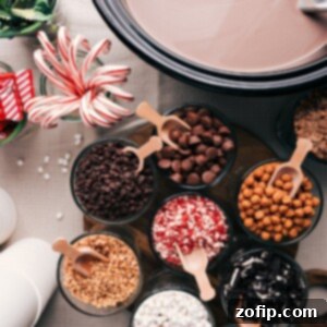 Assorted hot chocolate ingredients and toppings displayed on a table, including cups, chocolate shavings, whipped cream, and marshmallows.