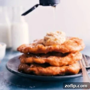 A plate of golden Utah Scones, drizzled with honey and dusted with powdered sugar, ready to be enjoyed.