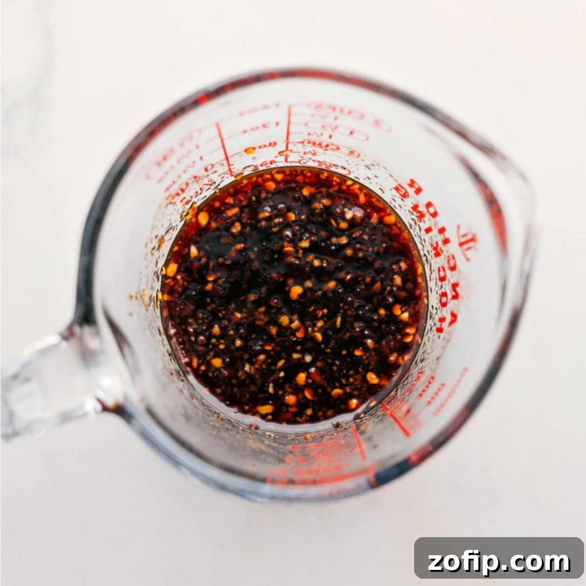 The Best Sauce In Dragon Noodles The vibrant, rich sauce for Dragon Noodles, perfectly combined in a liquid measuring cup, ready to be added to the stir-fry.